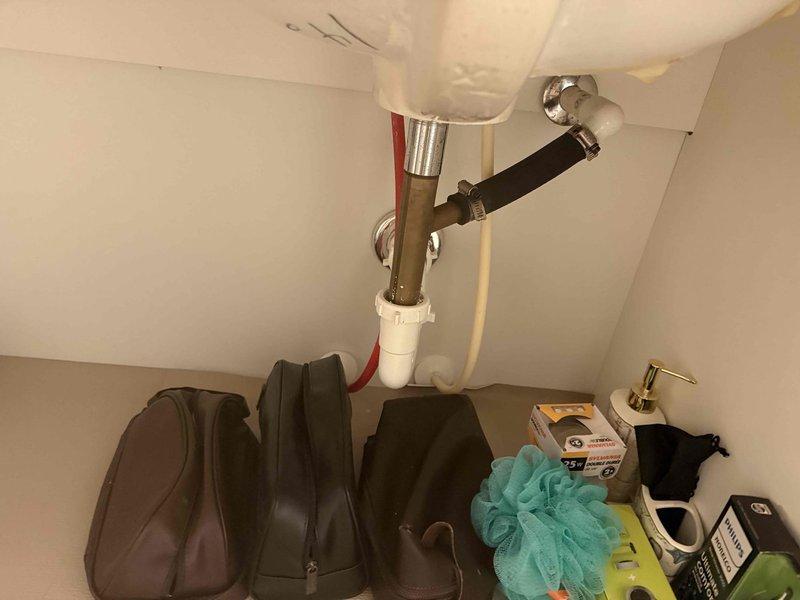 Responded to guest bathroom sink stoppage at 20-year-old residential property. Accessed plumbing assembly beneath vanity and cleared obstruction from P-trap and drain line, restoring full drainage function. Verified proper water flow and confirmed no leaks at trap connections upon completion.