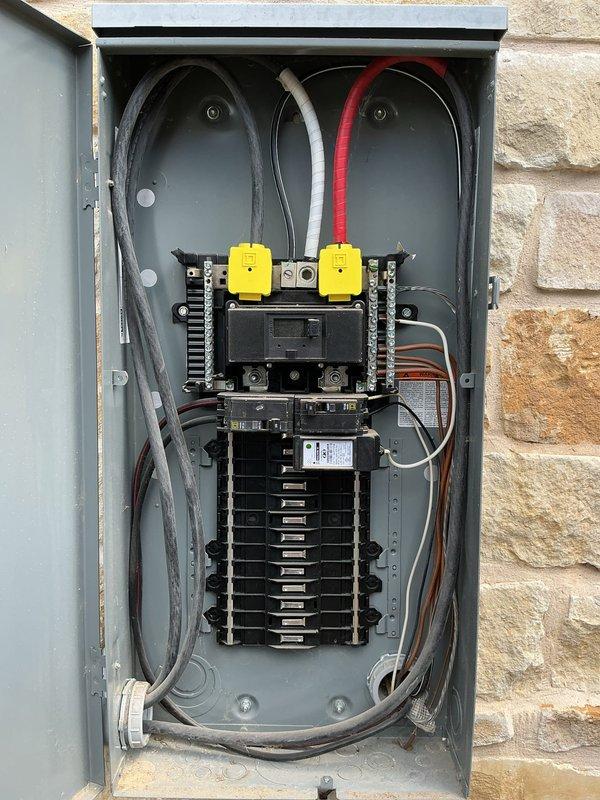 Responded to service call for GFCI outlet repeatedly tripping in garage at residential property. Upon arrival, conducted visual inspection of affected circuit and traced power source to main electrical panel mounted on exterior stone wall. Opened panel enclosure and performed comprehensive evaluation of circuit breaker configuration, wiring connections, and overall panel condition. 

Inspected all circuit breakers for proper seating, signs of overheating, or physical damage. Verified main breaker connections and examined wire routing throughout panel. Noted previous service notation dated April 2024 on panel door label. Tested GFCI outlet functionality and determined source of nuisance tripping. Identified issue with downstream wiring or connected load causing ground fault condition. 

Verified proper grounding and neutral bus connections within panel. Checked for moisture intrusion, corrosion, or loose terminations that could contribute to intermittent tripping. Documented panel confi