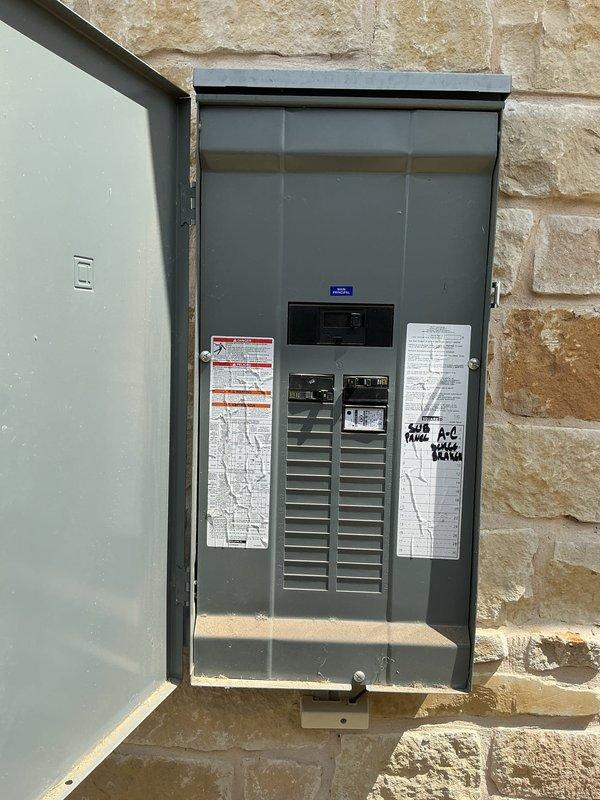 Responded to service call for GFCI outlet repeatedly tripping in garage at residential property. Upon arrival, conducted visual inspection of affected circuit and traced power source to main electrical panel mounted on exterior stone wall. Opened panel enclosure and performed comprehensive evaluation of circuit breaker configuration, wiring connections, and overall panel condition. 

Inspected all circuit breakers for proper seating, signs of overheating, or physical damage. Verified main breaker connections and examined wire routing throughout panel. Noted previous service notation dated April 2024 on panel door label. Tested GFCI outlet functionality and determined source of nuisance tripping. Identified issue with downstream wiring or connected load causing ground fault condition. 

Verified proper grounding and neutral bus connections within panel. Checked for moisture intrusion, corrosion, or loose terminations that could contribute to intermittent tripping. Documented panel confi