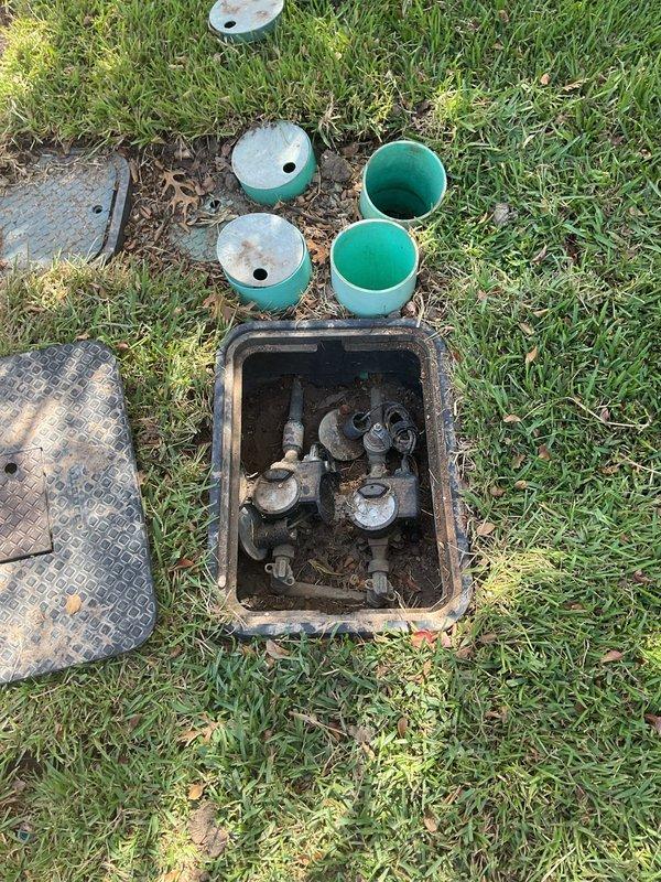 Responded to service request for pressure reducing valve (PRV) inspection at 2,380 sq ft residential property built in 2006. Located and accessed ground-level valve box in lawn area, which contained PRV assembly with visible signs of age, corrosion, and soil accumulation on valve body and fittings. Removed irrigation system riser components and access covers to gain full access to valve assembly. Connected calibrated pressure gauge to test ports on PRV system using brass fittings and quick-connect couplings. Measured and recorded static water pressure readings using ProFlo dial gauge to verify valve operation and downstream pressure regulation. Valve assembly showed weathering consistent with underground utility infrastructure exposure. Documented valve condition, pressure readings, and overall system status with photographic evidence. Valve box and surrounding components exhibited corrosion on metal surfaces and dirt accumulation from years of service. This represented the first plumb