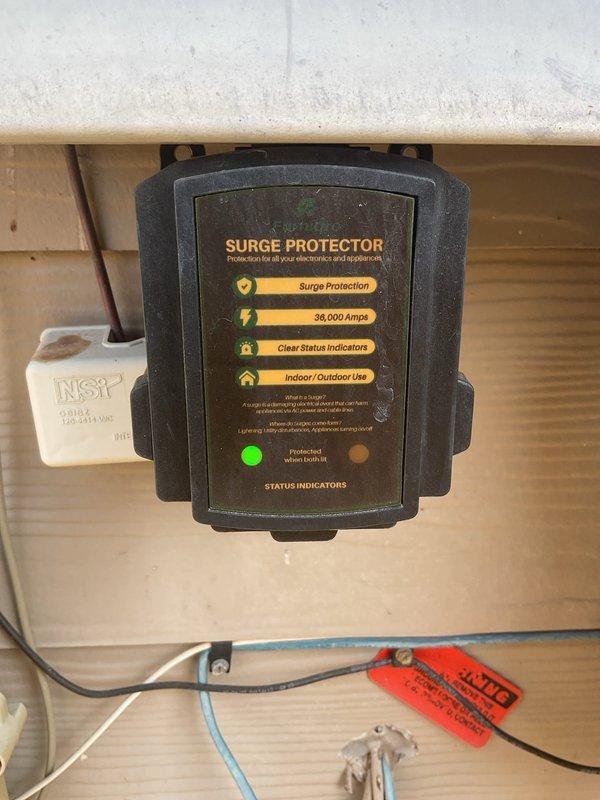 Responded to electrical service call regarding surge protection system concerns identified during previous whole-home maintenance inspection. Upon arrival, assessed existing surge protection device and electrical panel configuration. Identified improper wiring connections at main breaker panel affecting surge protector functionality. Corrected surge protection wiring to ensure proper operation and verified device status indicators showing active protection at 38,000 amp rating. Documented existing panel conditions including circuit breaker arrangement and bus bar connections with photographic evidence. Provided estimate for immediate surge protection concerns as requested, noting additional wiring configuration issues present that may require future attention.