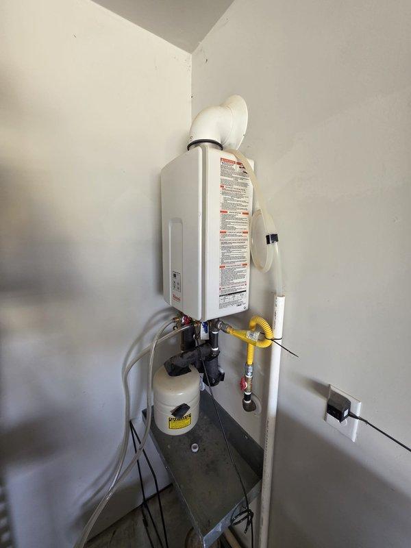 Completed comprehensive plumbing maintenance on 4-year-old gas tankless water heater system located in garage. Inspected all water supply connections, gas line connections with shut-off valve, exhaust venting, condensate drain line, and expansion tank for proper operation and safety compliance. Verified all pipe fittings, flexible gas line, and pump assembly connections are secure with no signs of leaks or corrosion, and confirmed system is operating within manufacturer specifications.