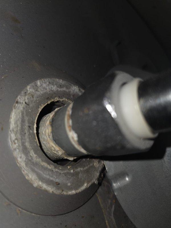 Performed preventive maintenance flush on 5-year-old gas tank water heater at 1997-built residential property. Drained sediment buildup from tank bottom through drain valve, flushed system with fresh water to remove mineral deposits and debris, and verified proper operation of temperature/pressure relief valve. Inspected gas supply line connections including brass shut-off valve and flexible copper connector for leaks and proper installation, confirmed secure mounting and code-compliant configuration. Examined pipe penetrations and insulation integrity at mechanical connections, noting existing insulation condition around ductwork pass-throughs. All components tested and returned to normal operation with no leaks detected upon completion of flush procedure.