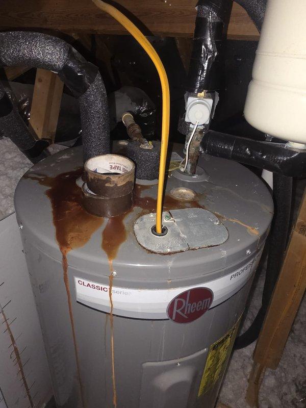 Responded to no hot water complaint at residential property. Upon inspection, found existing Rheem Classic series water heater exhibiting significant rust staining and corrosion at top connections, with visible moisture damage on surrounding floor indicating active leak at tank fittings. Assessed unit condition and determined water heater required replacement due to compromised tank integrity and failed connections. Installed new water heater unit, connected all necessary water supply lines and gas connections per manufacturer specifications and local code requirements, and verified proper operation with full system testing.