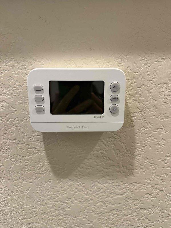 Responded to service call for non-functioning thermostat display on 8-10 year old HVAC system. Inspected Honeywell Home Smart thermostat and traced low voltage wiring to air handler control board, where loose wire connections were identified and secured with proper terminations. Verified system operation and restored thermostat functionality upon completion.