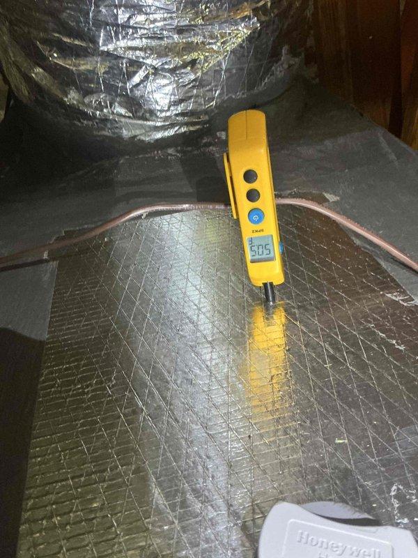 Responded to warranty callback for high-pitched noise originating from attic-mounted HVAC system during blower operation. Accessed attic to inspect less than one-year-old system that had previous warranty work including supply plenum replacement and zone damper enlargement from 12" to 14". Performed diagnostic assessment of ductwork, blower assembly, and plenum connections using digital measurement equipment, recording static pressure reading of 505 CFM at supply plenum. Inspected insulated ductwork and refrigerant lines for vibration points or contact with structural members that could generate audible noise during airflow. System remains under manufacturer warranty; documented findings and recommended follow-up for noise source identification and resolution.