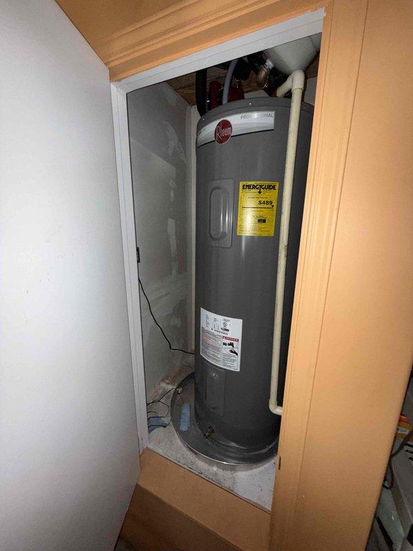 Completed comprehensive plumbing member maintenance on a 2-year-old electric tank water heater located in the garage. Performed full system inspection including visual assessment of tank condition, pipe connections, and circulation pump operation. Verified proper functioning of all plumbing components, checked temperature and pressure relief valve, inspected anode rod condition, and examined all supply and discharge piping for signs of corrosion or leaks. Evaluated hot water recirculation system with red circulation pump and associated black piping assembly. Confirmed adequate clearance around unit and proper venting configuration. All components found to be operating within normal parameters with no immediate service needs identified at time of inspection.