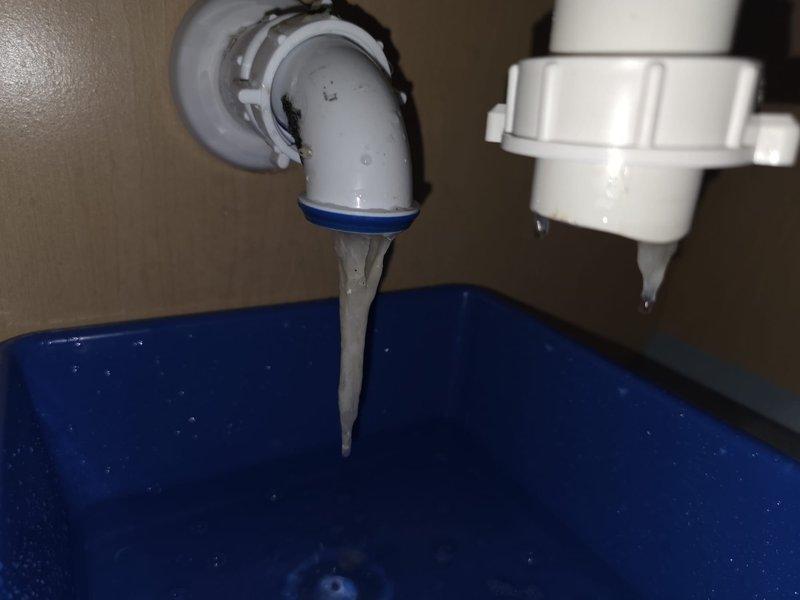 Responded to ongoing clogged sink issue in upstairs bathroom. Upon inspection, discovered severe mineral buildup and scaling within the PVC drain piping causing restricted flow. Disassembled P-trap assembly and elbow fittings, revealing significant calcium and sediment deposits accumulated on interior pipe walls. Removed affected sections of drain line and thoroughly cleaned all components. Replaced compromised fittings with new PVC connections to restore proper drainage. Tested system to confirm full flow restoration and proper operation of sink drain.