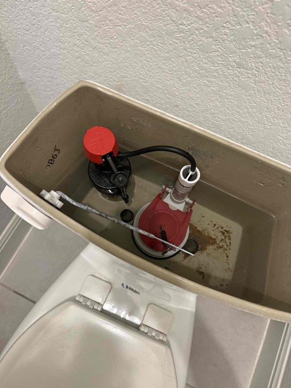 Responded to no-charge follow-up visit for constantly running toilet in master bathroom. Inspected toilet tank and identified worn flush valve assembly and deteriorated flapper causing continuous water flow. Tank interior showed significant mineral deposits and sediment buildup on bottom and walls, consistent with hard water conditions and 8-year-old fixture age. Replaced defective flush valve components and flapper seal to restore proper shutoff function. Adjusted fill valve water level and verified complete flush cycle operation. Toilet now functioning properly with no continuous running or water waste.