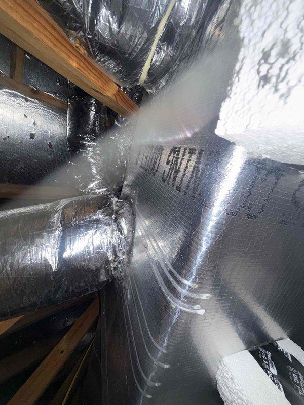 Completed preventive maintenance on a 2021 central air conditioning system located in the attic and garage area of a 2,022 square foot residence. Inspected and serviced the HVAC unit, including examination of ductwork connections, flexible ducting, and sheet metal supply lines with reflective insulation wrapping. Verified proper installation of floor register and vent connection points, confirmed all ductwork seams and connections were secure, and assessed attic accessibility and overall system condition to ensure optimal performance during peak cooling demands.