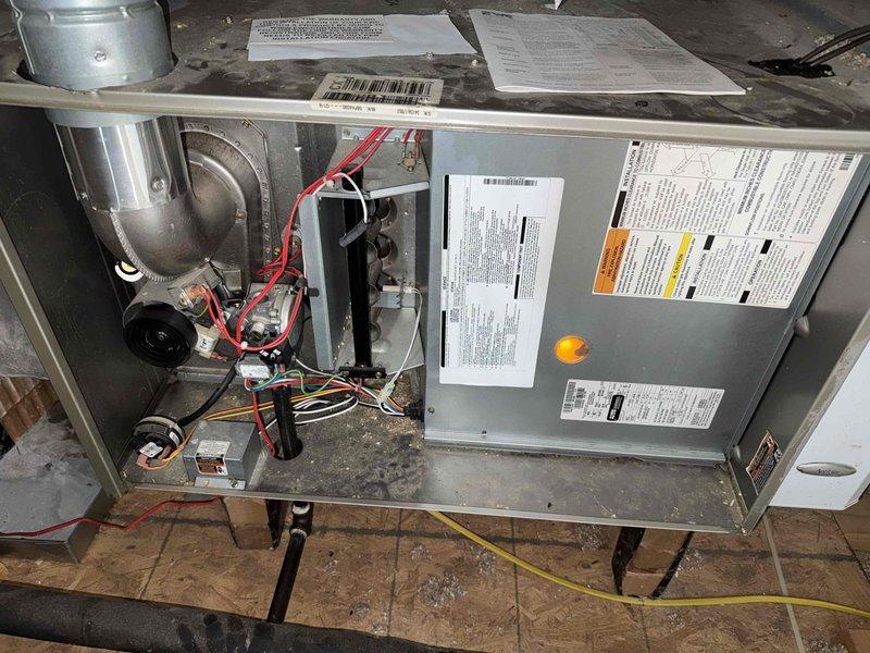 # HVAC Service Completed

Responded to service call for 13-year-old HVAC system with no airflow despite unit running. Upon arrival, performed comprehensive system inspection of both indoor air handler and outdoor condensing unit. 

Removed access panel from indoor air handler unit to inspect blower assembly and internal components. Found blower motor operational but identified airflow restriction issue. Inspected blower wheel, motor assembly, and electrical connections. Verified proper voltage supply and motor operation.

Proceeded to outdoor condensing unit where significant debris accumulation was discovered. Heavy buildup of dried leaves and organic material was blocking airflow at base and around condenser coil. Condenser coil showed substantial dirt and debris accumulation on fins, severely restricting heat transfer capability and system efficiency.

Cleared all leaves and organic debris from around unit perimeter and base. Cleaned condenser coil to restore proper airflow through 