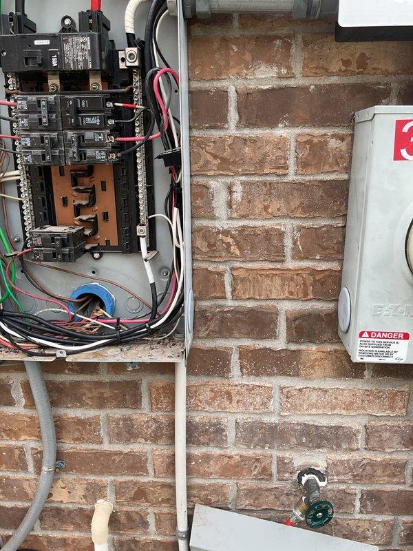 Performed site evaluation for Tesla electric vehicle charger installation at 13-year-old residence. Inspected existing electrical infrastructure, including 150-amp main service panel mounted on exterior brick wall. Documented panel configuration showing available breaker spaces, current load distribution, and existing wire routing. Evaluated main breaker capacity, bus bar connections, and grounding system to determine suitability for EV charger circuit addition. Assessed conduit pathways and potential installation locations for Level 2 charging equipment. Photographed panel interior and exterior components to support accurate project quotation and material requirements.
