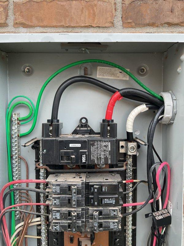 Performed site evaluation for Tesla electric vehicle charger installation at 13-year-old residence. Inspected existing electrical infrastructure, including 150-amp main service panel mounted on exterior brick wall. Documented panel configuration showing available breaker spaces, current load distribution, and existing wire routing. Evaluated main breaker capacity, bus bar connections, and grounding system to determine suitability for EV charger circuit addition. Assessed conduit pathways and potential installation locations for Level 2 charging equipment. Photographed panel interior and exterior components to support accurate project quotation and material requirements.