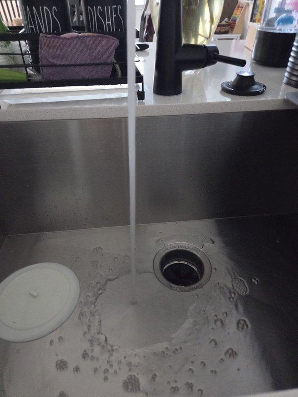 Responded to service call for inoperative garbage disposal unit that was receiving power but failing to rotate. Upon inspection, discovered the disposal flywheel was jammed with accumulated debris and foreign material lodged in the grinding chamber. Manually freed the impeller assembly, removed obstructing material, and restored full operational function. Tested unit under running water to verify proper grinding action and drainage, confirming complete resolution of the issue.