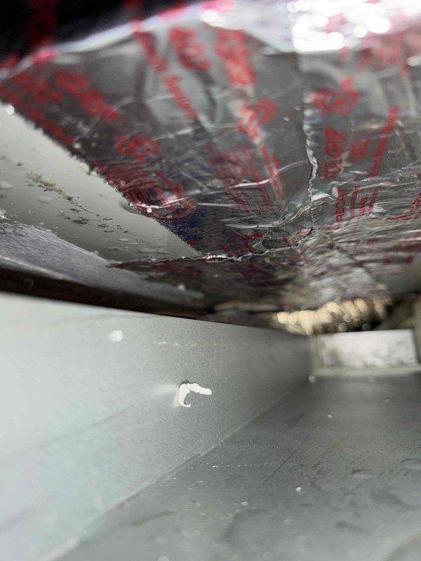Returned to the attic-installed air handler with a second technician to replace the secondary drain pan and filter base. Found microbial growth on the cabinet panels, moisture and staining beneath the unit, and condensation present in the plenum. Removed and replaced the deteriorated secondary pan and filter base, reset the unit on a stable support, and confirmed the primary drain line and float switch were properly positioned.