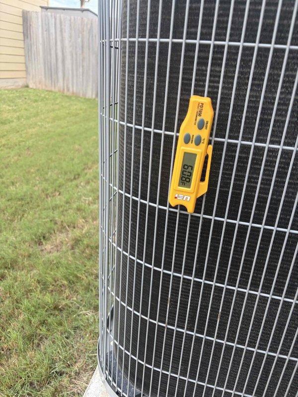 Performed a member maintenance inspection on a 6-year-old split system with an attic-mounted air handler and outdoor condenser. Inspected the condenser coil and guard grille, finding no frost, rust, or visible damage, and measured ambient air temperature at the condenser. Used a clamp meter to check electrical operation of the outdoor unit, including amperage draw at the wiring and capacitor/motor section, and verified the line-set conduit and wiring connections were intact.