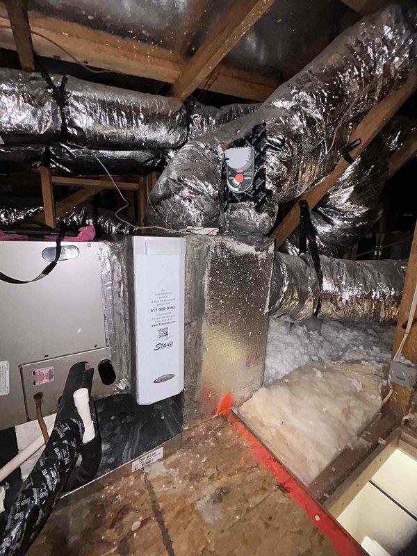 Performed annual maintenance on a single attic-mounted split system (installed 2018), inspecting the air handler, evaporator drain lines, supply plenum, and flex duct runs for integrity, with no air leaks or deficiencies noted at the previously sealed duct connections. Verified operation of the installed media air cleaner and the Bioforce Defender UV system, confirming both units were powered with indicator lights illuminated, and confirmed the attic work area remained clean, accessible, and properly insulated.