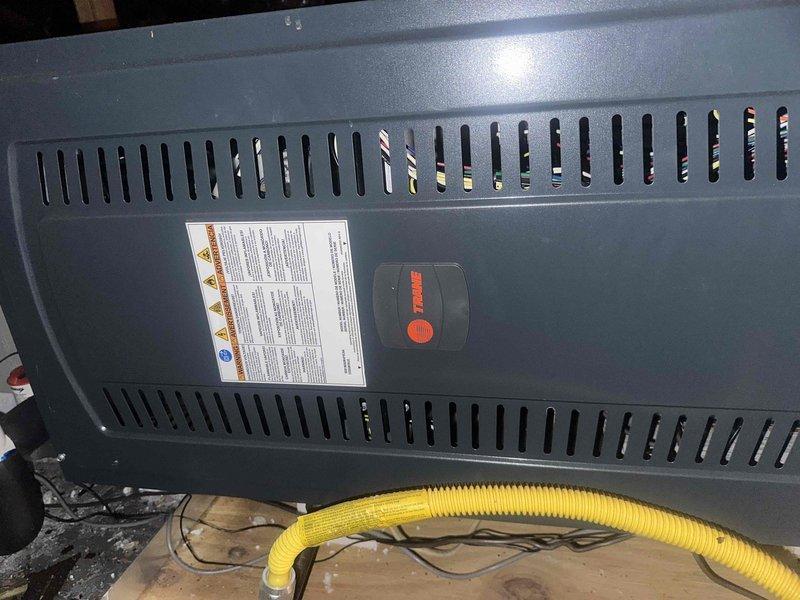 Performed seasonal preventive maintenance on a Trane gas furnace and air handler system located in the attic. Inspected the cabinet, gas connection, electrical wiring, condensate drain assembly with float switch, and secondary drain components. Noted heavy dust and debris accumulation on the metal drain pan and platform area, and recommended cleaning to maintain proper drainage and airflow. System appeared to be operating normally with no comfort concerns reported.
