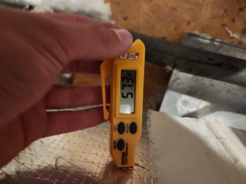 Performed seasonal maintenance on the attic-mounted split system, including a supply air temperature check with a digital probe thermometer, which measured approximately 57°F at the duct. Inspected the supply plenum and found heavy dust and debris accumulation on the insulation liner, with visible discoloration and spotting on the upper wall, worn areas on the floor lining, and serrated collar connections intact. Recommend evaluating plenum cleaning and insulation remediation to maintain air quality and system efficiency.