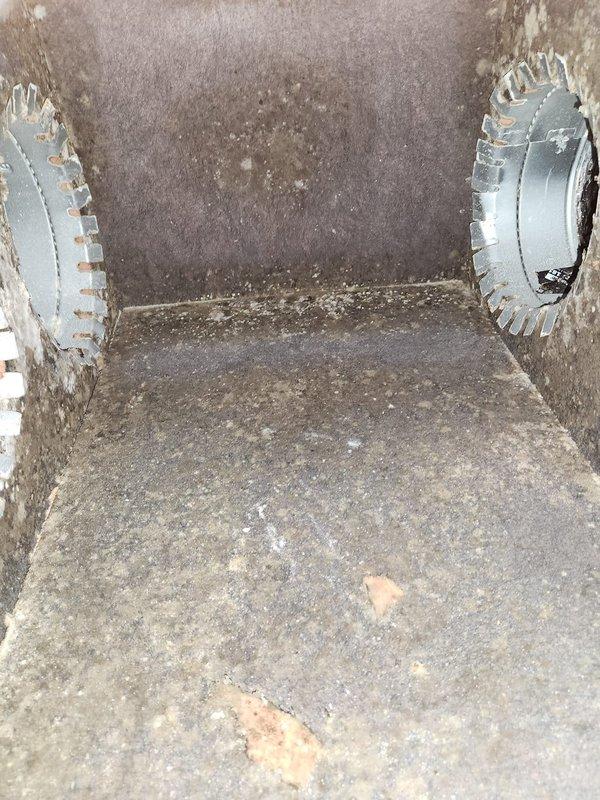 Performed seasonal maintenance on the attic-mounted split system, including a supply air temperature check with a digital probe thermometer, which measured approximately 57°F at the duct. Inspected the supply plenum and found heavy dust and debris accumulation on the insulation liner, with visible discoloration and spotting on the upper wall, worn areas on the floor lining, and serrated collar connections intact. Recommend evaluating plenum cleaning and insulation remediation to maintain air quality and system efficiency.