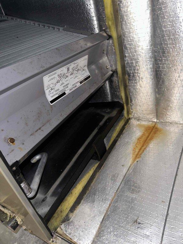 Returned to complete scheduled maintenance on the air handler. Inspected the blower wheel and cabinet interior, noting dust and debris accumulation on the squirrel cage fan blades, rust staining on the foil-faced insulation and cabinet floor, and surface corrosion on the frame and fasteners near the drain pan. Documented all conditions for further evaluation and recommended follow-up as needed.