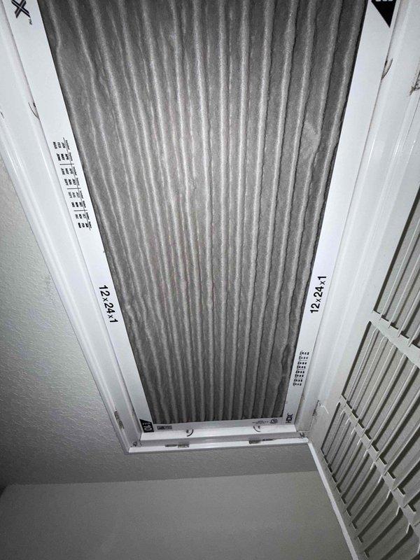 Performed a seasonal preventive maintenance inspection on a single attic-mounted split system. Inspected the 12x24x1 return air filter, which was heavily loaded with dust and debris, and documented its condition for replacement. Inspected the attic flex duct and found torn and frayed foil-faced insulation jacketing with exposed fiberglass, which can lead to thermal loss and condensation; documented for repair. Previously identified restricted return airflow and biological growth in the plenum and evaporator coil remain open items for follow-up.