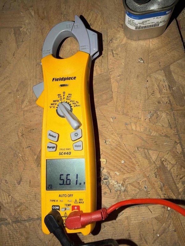 Performed a combination tune-up on a single attic-mounted split system consisting of a 4–5 year old condenser paired with the original air handler and furnace. Inspected the control board and low-voltage wiring, and tested the condenser run capacitor with a true RMS clamp meter, measuring 5.61 µF against its 7.5 µF rating. This indicates a capacitor reading below tolerance that should be monitored or replaced to prevent a future hard-start or compressor failure.