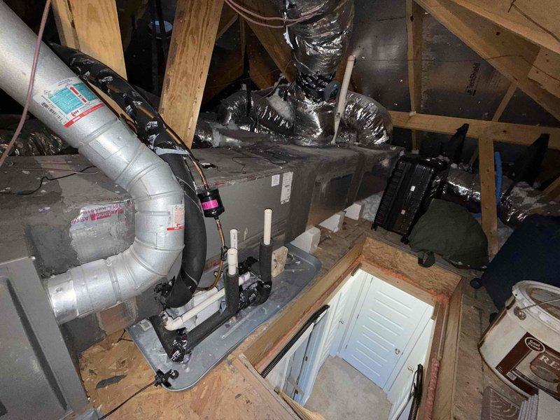 Performed member maintenance inspection on a single attic-mounted split system. Measured blower motor amperage at 0.51 A with a true RMS clamp meter. Found frost/ice buildup on the insulated refrigerant lines and fittings at the base of the air handler, which indicates a restricted airflow or low refrigerant charge condition. Condensate drain piping and secondary drain pan were inspected. Further diagnosis of airflow and refrigerant charge is recommended to determine the cause of the freeze-up.
