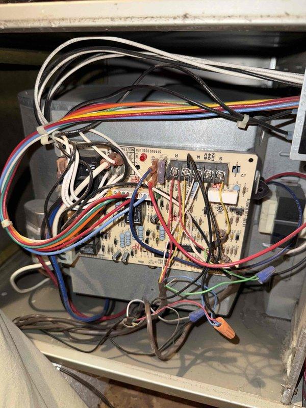 Responded to a no-heat call with cold air at the registers on an attic-installed furnace. Inspected the control board and low-voltage wiring and tested the run capacitor with a clamp meter, measuring 5.07 µF against a 7.5 µF rating, which is outside tolerance and indicates a weak capacitor. Observed dust buildup and disorganized, loosely routed wiring in the control compartment.