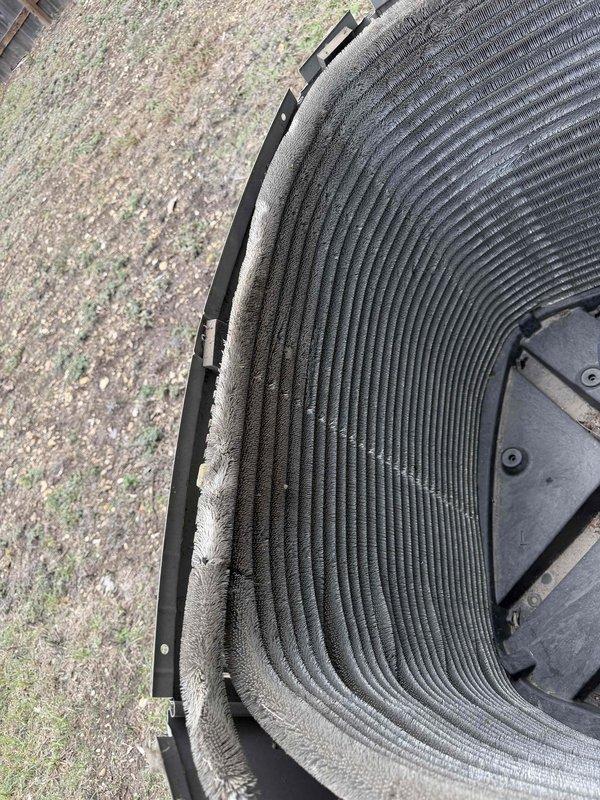 Performed member maintenance inspection on the outdoor condenser unit, removing the top grille and fan assembly to access the interior. Found the condenser coil fins heavily clogged with matted dust and lint buildup, restricting airflow and reducing heat transfer efficiency. The coil was cleaned to remove the debris, and the compressor, refrigerant lines, and wiring were visually inspected with no issues noted.