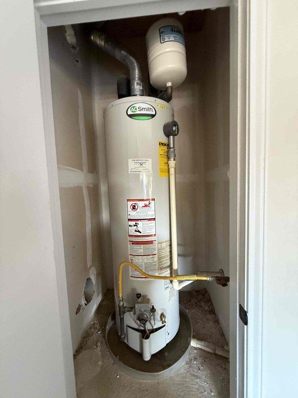 Performed a flush on the gas-fired A.O. Smith tank-style water heater, which is installed in a closet with an expansion tank, flexible gas connection, vent connector, and drain pan. Water testing was also completed using a test kit to evaluate water quality conditions. The unit is about 12 years old and nearing the end of its typical service life, so the system was evaluated for future replacement planning.