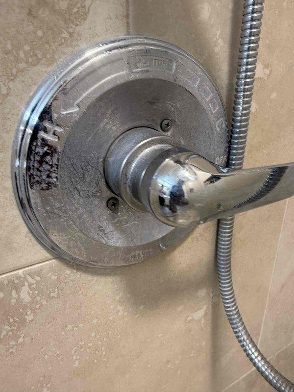Performed a water heater flush on the 5-year-old electric tank unit and evaluated the primary bathroom's low water pressure complaint. Inspected the shower valve trim and found heavy scratching, mineral buildup, and corrosion on the escutcheon plate, indicating wear and possible scale restriction at the valve. Also noted staining and grime at the water heater base and closet floor pan, with the thermal expansion tank in place, and recommended continued annual maintenance to protect the heater and maintain system performance.