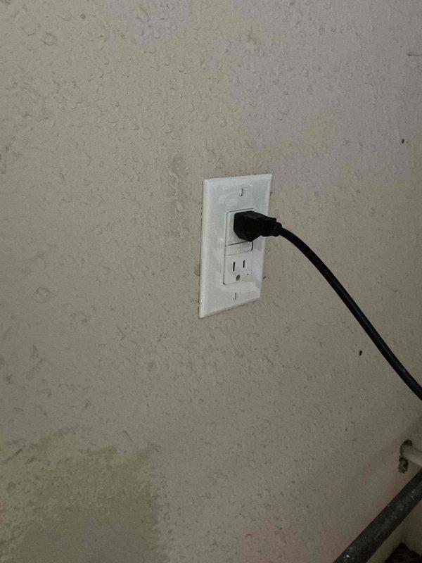 Installed a new GFCI-protected receptacle in the utility closet to serve the tankless water heater, mounting it with a matching cover plate and securing it to the wall. Connected the unit's power cord to the receptacle and verified proper operation, with the cord routed cleanly away from the gas piping and fittings.