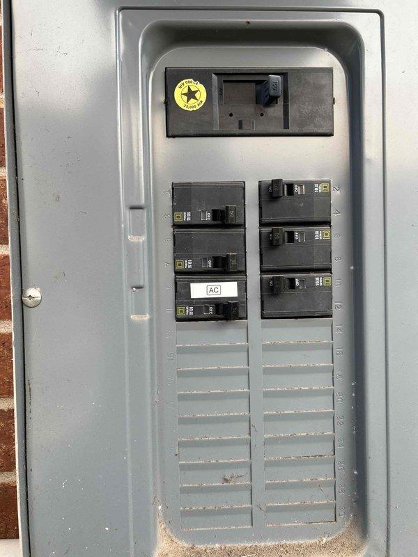 Returned to site to correct a failed inspection item by labeling the AC circuit breaker at the main electrical panel, ensuring the breaker is clearly identified as "AC" for the condensing unit circuit. Verified the exterior AC disconnect and surge protection device are securely mounted, properly labeled with "OVER LOAD PROTECT AT MAIN PANEL," and the flexible conduit is clamped and routed correctly.