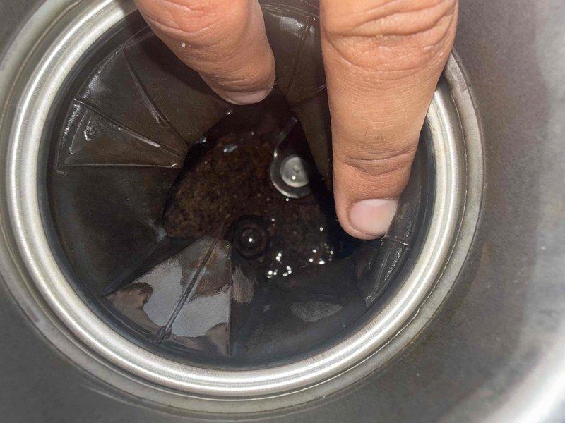 Inspected the kitchen garbage disposal for the reported leak and repeated breaker trips. Found the disposal chamber coated with wet food residue and moisture present, consistent with a failing seal or leak at the unit. Evaluated the electrical and plumbing connections at the disposal and addressed the leak source. Also assessed the under-sink reverse osmosis filtration system for filter servicing needs.