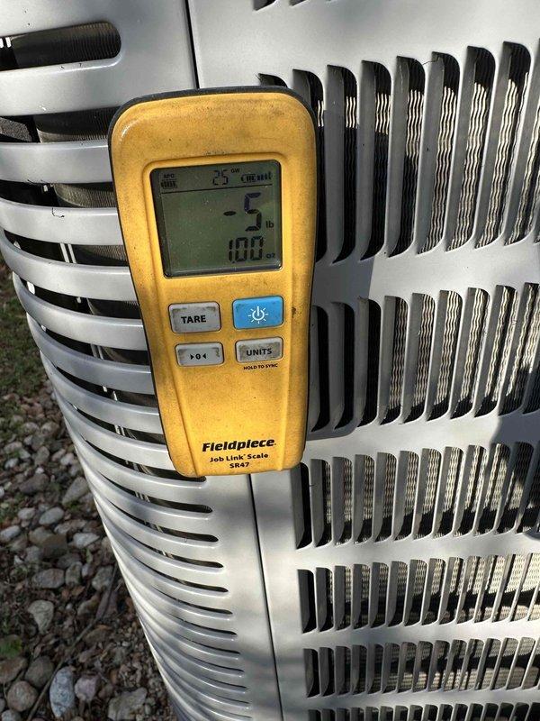 Performed warranty service on the outdoor condensing unit using a Fieldpiece Job Link SR47 refrigerant scale to measure refrigerant weight during charge adjustment. Tared the scale and monitored recovered/added refrigerant quantities to verify the system was brought to the correct charge specification.
