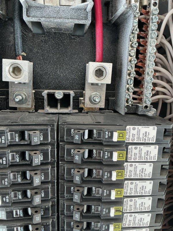 Inspected the main electrical panel and the dryer circuit as part of a GFCI breaker evaluation for the dryer. Examined the main lugs, conductor terminations, neutral/ground bus, and branch breakers for signs of overheating, loose connections, or damage. Verified the dryer, oven, generator, and sub-panel breakers were properly rated and labeled. Observed no burn marks, rust, or visible damage, though a grainy residue was noted on the main lug surfaces and some breaker handle bases. Panel was left in working condition.