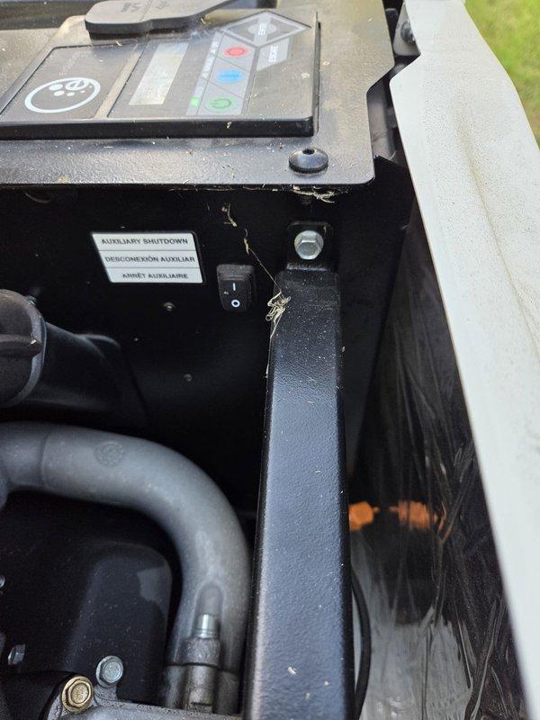 Responded to a standby generator showing a red fault indicator and loss of communication. Opened the enclosure and performed a visual inspection of the control panel, auxiliary shutdown switch, cooling hose routing, and engine compartment, noting light dust and cobweb buildup with no visible rust, frost, or physical damage. Verified the unit is seated on its composite pad with the flexible conduit connection intact.
