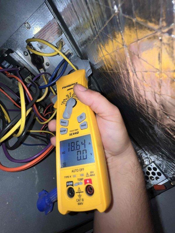 Performed a member maintenance visit on a single 5-year-old residential HVAC system located in a closet. Inspected the equipment compartment and control wiring, and measured operating amperage with a true RMS clamp meter, recording 18.64 A on the monitored conductor to verify the system was drawing current within normal operating range. Verified thermostat operation on the wall-mounted Nest unit, confirming the display, setpoint, and temperature readings were functioning properly.