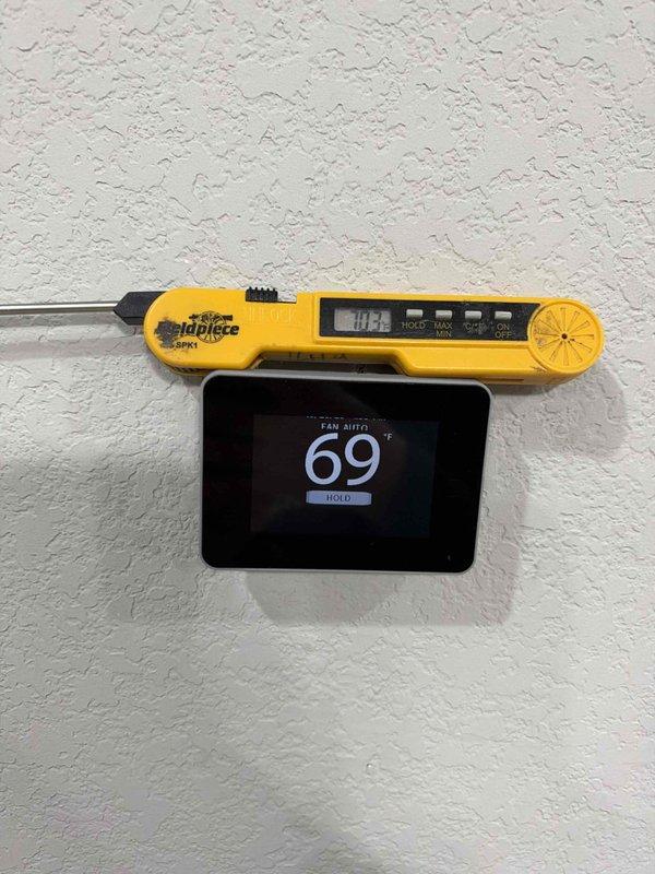 Returned to site to complete the HVAC system installation. Verified thermostat operation in FAN AUTO mode and confirmed the displayed setpoint against a calibrated probe thermometer reading. Inspected the outdoor condensing unit connections, including the electrical disconnect, flexible conduit, and insulated refrigerant line set, and found all components properly secured with no visible damage.