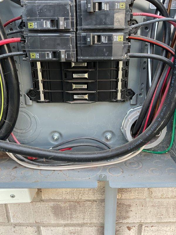 Performed a member electrical maintenance inspection of both breaker enclosures, the garage sub panel and the exterior-mounted service panel, in a two-year-old home. Visually inspected the Square D breakers, bus bar assemblies, conductors, and enclosure interiors, noting AFCI/GFCI combination breakers in the garage panel and 30A/50A breakers with intact cable routing in the exterior panel. Observed no signs of overheating, damaged conductors, or loose terminations, and noted minor construction dust and debris in the enclosures, with open breaker spaces available for future circuit additions.