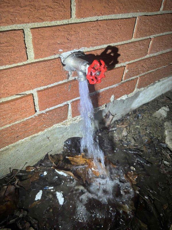 Responded to after-hours service call for broken outside spigot actively leaking from brick wall. Replaced damaged exterior faucet showing deterioration at connection point with new unit, eliminating water flow issue and preventing further moisture damage to foundation area.