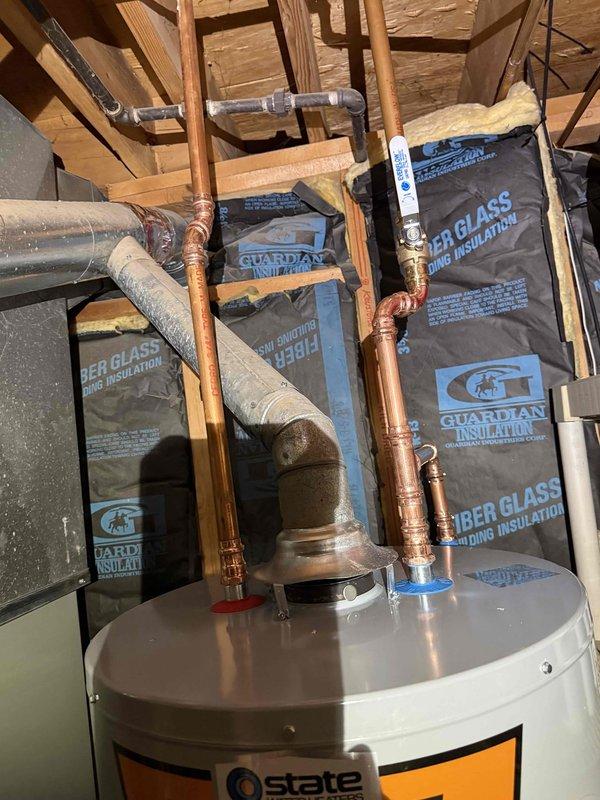 Successfully installed a 40-gallon State ProLine Commercial Grade gas water heater with thermal expansion tank in utility area. Completed all necessary copper pipe connections with soldered joints and installed appropriate valves. Installation included proper venting and connection to existing gas line per manufacturer specifications.