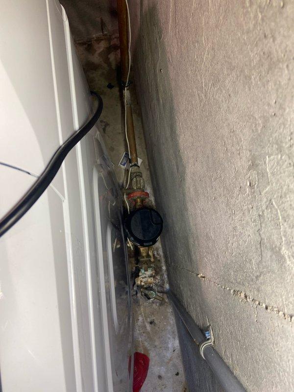 Replaced corroded hot and cold water supply valves serving washing machine in basement. Installed new brass valves with quarter-turn handles and connected flexible stainless steel braided supply lines to complete the installation.