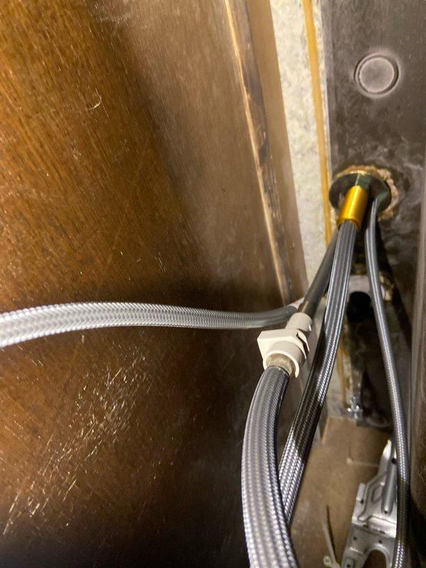 Successfully installed customer-supplied black kitchen faucet with tall, arched design on granite/stone countertop. Properly connected water supply lines through existing access point and verified functionality of the new fixture. All connections were secured and tested to ensure no leaks.