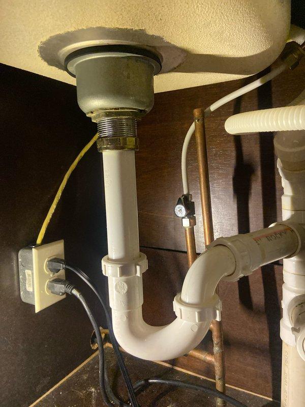 Diagnosed water leak at kitchen sink originating from corroded brass fitting connecting to copper supply line, not related to previous garbage disposal repair. Replaced deteriorated fitting and checked all connections to ensure proper function with no further leakage.