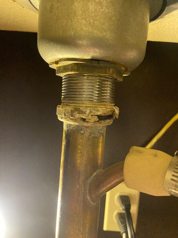 Diagnosed water leak at kitchen sink originating from corroded brass fitting connecting to copper supply line, not related to previous garbage disposal repair. Replaced deteriorated fitting and checked all connections to ensure proper function with no further leakage.