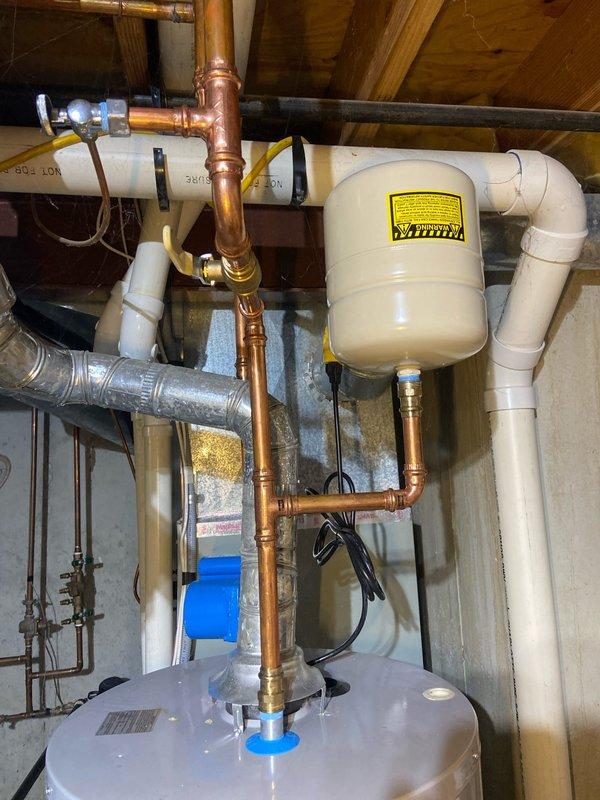 Conducted a comprehensive whole-home plumbing inspection as requested by customer. Examined water heater system with associated copper piping, expansion tank, and PVC drainage components in utility area, noting all were in normal working condition. Inspected main water supply configuration including copper pipe network, brass valves, and water meter/pressure regulator, observing some historical water staining around pipe connections but no active leaks or immediate concerns.
