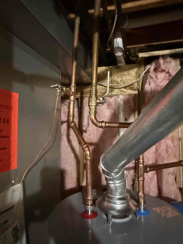 Successfully installed a new 40-gallon gas water heater with proper copper pipe connections and fittings. Added a blue expansion tank to the system to prevent pressure buildup. All connections were secured and tested, with the complete system properly integrated into the existing plumbing infrastructure with hot and cold water lines clearly identified.