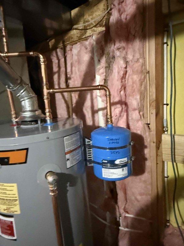 Successfully installed a new 40-gallon gas water heater with proper copper pipe connections and fittings. Added a blue expansion tank to the system to prevent pressure buildup. All connections were secured and tested, with the complete system properly integrated into the existing plumbing infrastructure with hot and cold water lines clearly identified.